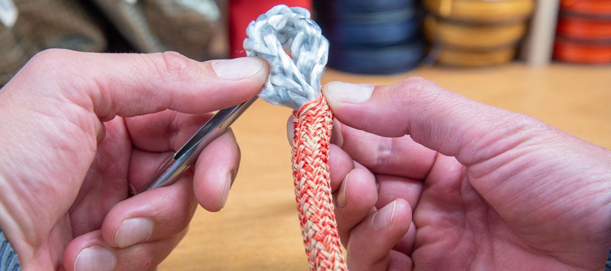 Splicing a red rope with a hollow splicing needle